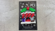 Vibrant fireplace ornament with holly and presents, displaying 4 red stockings, shown on backing card and Christmas tree.