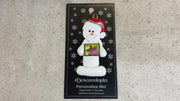 Ornament of white snowman in red hat holding a postal stamp, shown on backing card and Christmas tree.