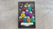 Christmas tree ornament decorated with 9 light bulbs with smiling faces, shown on backing card and decorated Christmas tree.