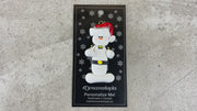 Ornament of white snowman in red hat wearing a striped police outfit, shown on backing card and Christmas tree.
