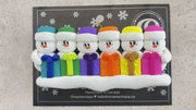 Family ornament with 6 white snowmen in colourful hats holding matching presents, shown on backing card and Christmas tree.