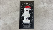 Ornament of white snowman in red hat holding dental x-ray and white tooth, shown on backing card and Christmas tree.