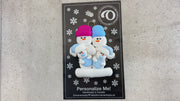 Family ornament with 2 large and 2 infant snowmen in blue, shown on backing card and Christmas tree.
