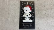 Ornament of white snowman in red hat holding a soccer ball, shown on backing card and Christmas tree.
