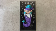 Elf poking out of purple stocking ornament, shown on backing card and Christmas tree.