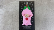 Ornament with an infant head poking out of a pink baby blanket, shown on backing card and Christmas tree.