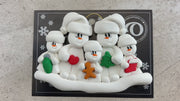 Family ornament with 2 large and 3 small snowmen in hats, holding holiday objects, shown on backing card and Christmas tree.