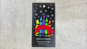 Stack of crayons joined with red ribbon teacher appreciation ornament, shown on backing card and Christmas tree.
