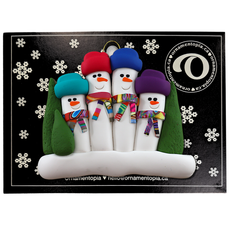 Family ornament with 4 snowmen in colourful scarves and hats, hemmed by Christmas trees, on display backing card.