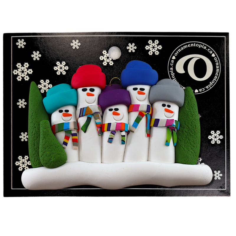 Family ornament with 5 snowmen in colourful scarves and hats, hemmed by Christmas trees, on display backing card.