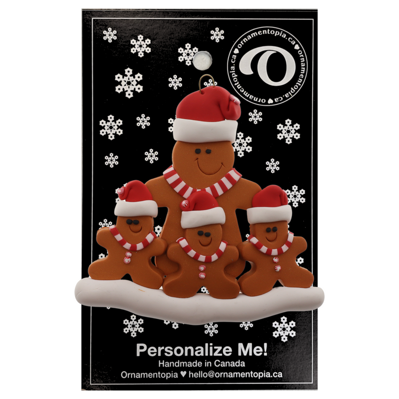Family ornament with 1 large and 3 small brown gingerbread figures in red Christmas hats, on display backing card.
