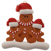 Family ornament with 1 large and 2 small brown gingerbread figures in red Christmas hats.
