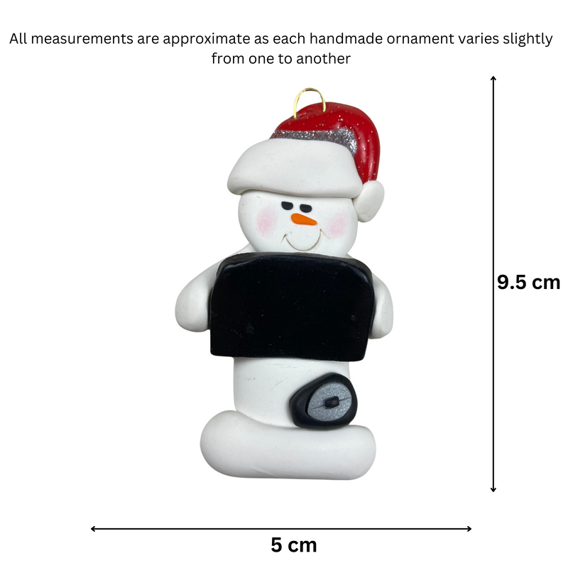 Ornament of white snowman in red hat holding black laptop and a computer mouse, graphed to show size (5x9.5cm).