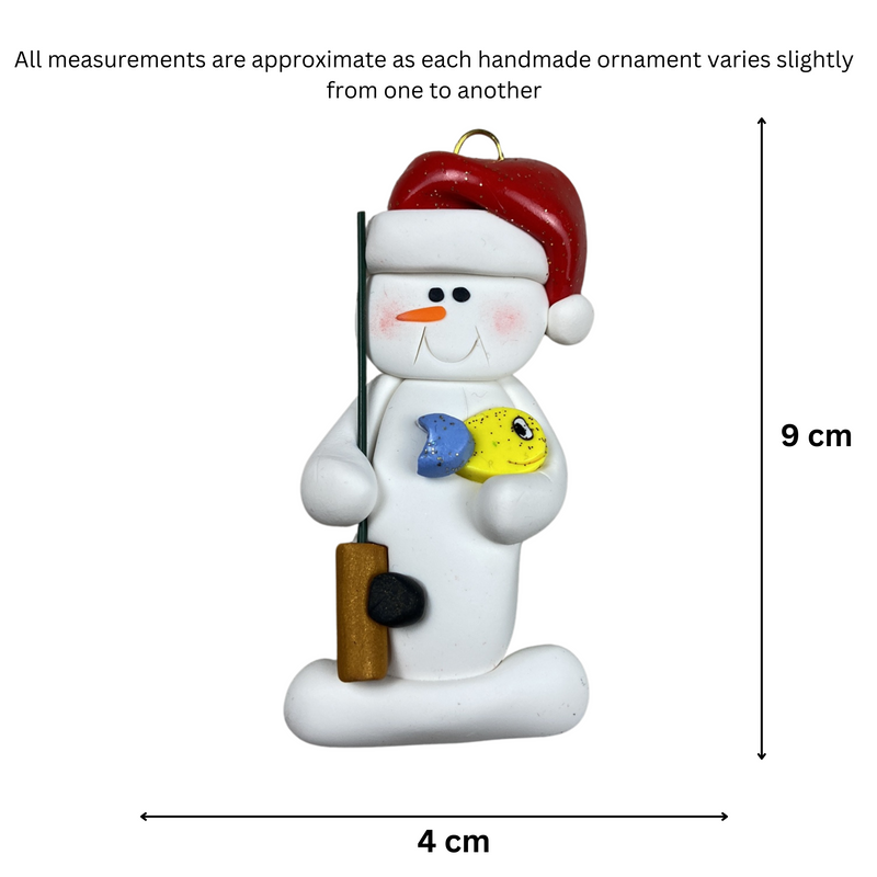 Ornament of white snowman in red hat holding a fishing pole and colourful fish, graphed to show size (4x9cm).
