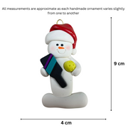 Ornament of white snowman in red hat holding a pickleball paddle and yellow pickleball, graphed to show size (4x9cm).