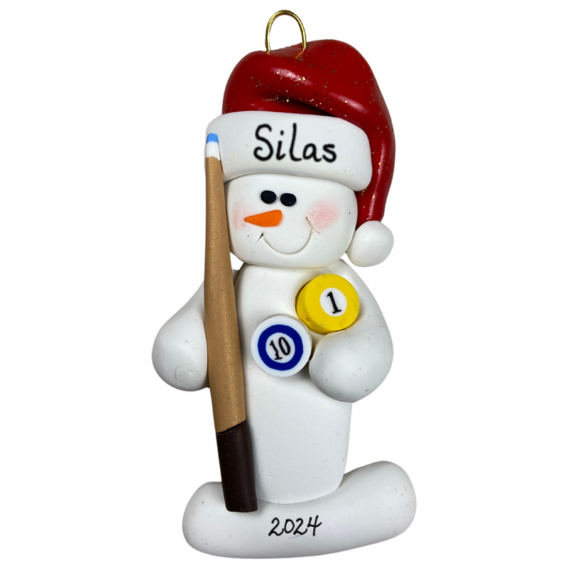 Ornament of white snowman in red hat holding a pool cue and pool balls, personalized with name.