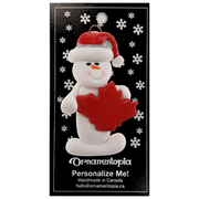 White snowman with red festive hat and maple leaf ornament, on display backing card.