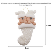 Ornament with twin infant heads in white glitter hats poking out of a white glitter stocking, graphed to show size (5x10cm).