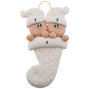 Ornament with twin infant heads in white glitter hats poking out of a white glitter stocking, numbered 1-3 for personalization.
