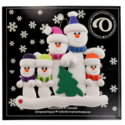 Family ornament with 5 white snowmen in bright scarves, with green Christmas tree, on display card backing.