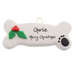 Ornament of dog bone with holly and paw print, personalized with name.