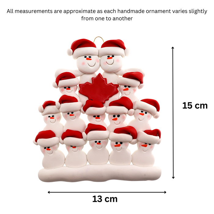 Family ornament with 14 white snowmen in red hats, gathered around a red maple leaf, graphed to show size (13x15cm).