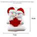 Family ornament with 2 white snowmen in red hats, gathered around a red maple leaf, graphed to show size (7x9cm).