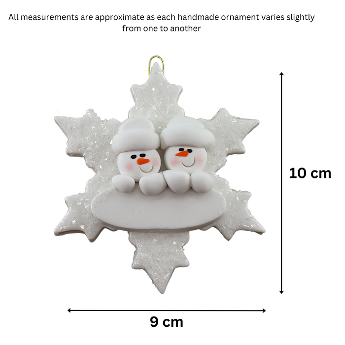 Family ornament with 2 white snowmen stacked on top of a glitter white snowflake, graphed to show size (9x10cm).