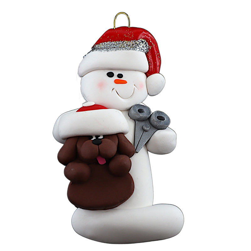 Ornament of white snowman in red hat holding a brown dog and a pair of scissors.