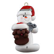 Ornament of white snowman in red hat holding a brown dog and a pair of scissors, numbered 1-2 for personalization.