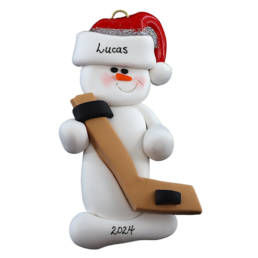 Ornament of white snowman in red hat holding a hockey stick and puck, personalized with name.