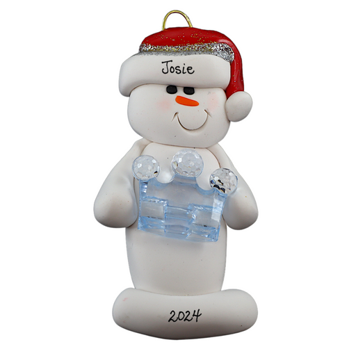 Ornament of white snowman in red hat holding a blue plastic crown, personalized with name.