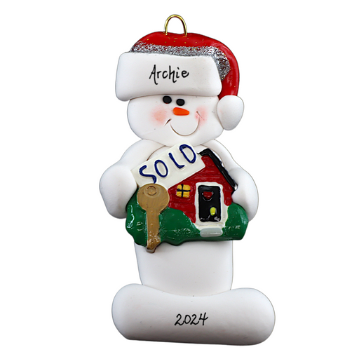 Ornament of white snowman in red hat holding a sign with a house saying “sold”, personalized with name.