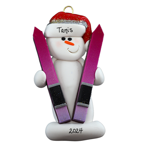 Ornament of white snowman in red hat holding a pair of vibrant skis, personalized with name.