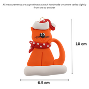 Ornament of orange cat in red and white polka dot Christmas hat and scarf, graphed to show size (6.5x10cm).