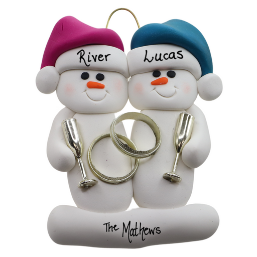 A couple’s ornament of two white snowmen holding gold rings and goblets, personalized with names.