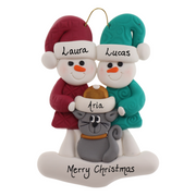 Ornament of snowman couple in red and green shirts and hats with grey cat in Christmas hat, personalized with names.