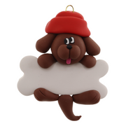 Ornament of brown dog in red hat hanging on a white bone.