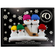 Family ornament with 5 white snowmen in bright hats, holding a hockey stick, on display backing card.