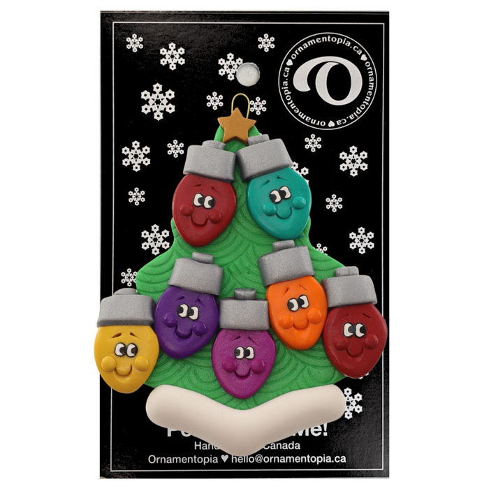 Christmas tree ornament decorated with 7 light bulbs with smiling faces, on display backing card.