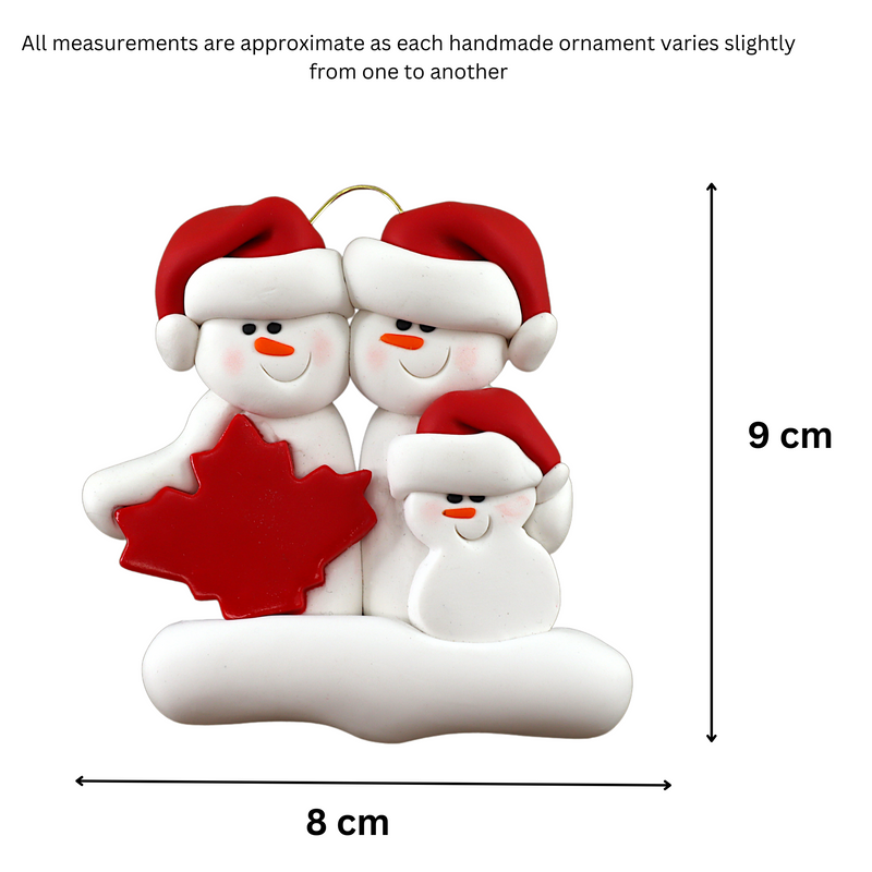 Family ornament with 3 white snowmen in red hats, gathered around a red maple leaf, graphed to show size (8x9cm).