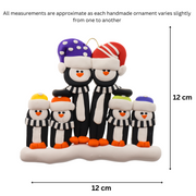 Family ornament with 6 black and white penguins in colourful festive hats, graphed to show size (12x12cm).