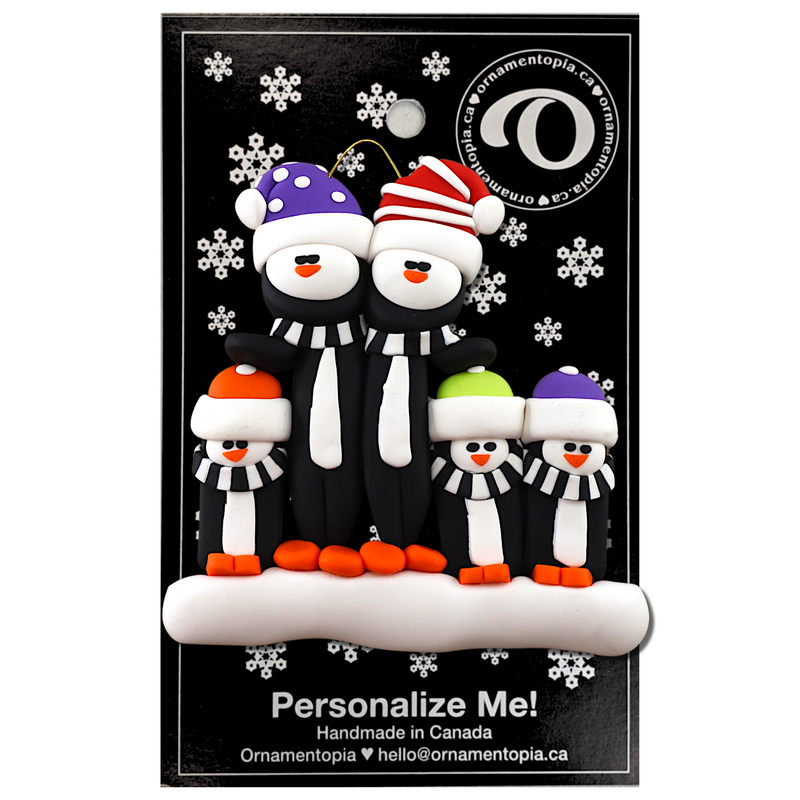 Family ornament with 5 black and white penguins in colourful festive hats, on display backing card.