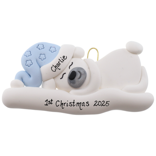 Ornament of white sleeping polar bear baby in a blue hat, personalized with name.
