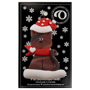 Ornament of brown cat in red and white polka dot Christmas hat and scarf, on display backing card.
