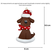 Ornament of brown dog in a red and white polka dot Christmas hat and scarf, graphed to show size (6x9.5cm).
