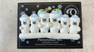 Family ornament with 6 polar bear figures in blue Christmas hats, shown on backing card and Christmas tree.