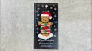 Tan bear in red festive hat holding colourful present ornament, shown on backing card and Christmas tree.