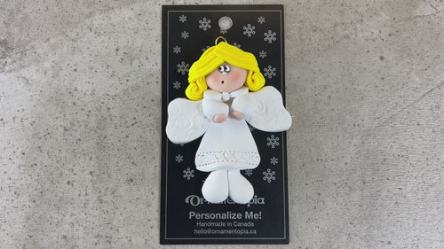 Angel wearing white with blonde hair ornament, shown on backing card and Christmas tree.