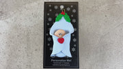Ornament with infant head poking out of a blue baby blanket, shown on backing card and Christmas tree.